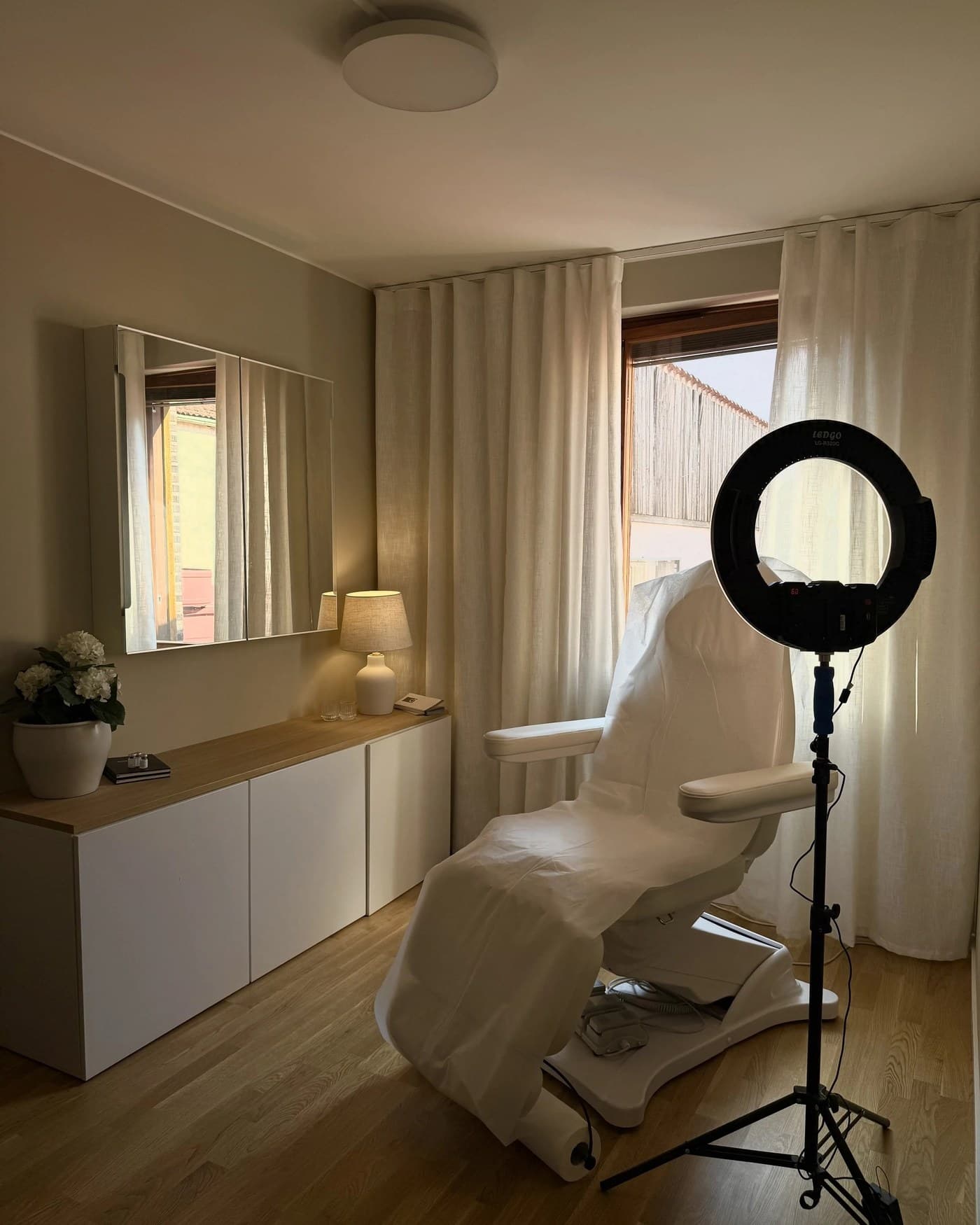 Behandlingsrummet med ringlampa, behandlingsstol och linnegardiner
